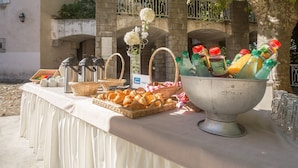 Un buffet proposant une variété de plats, un distributeur de boissons et un vase décoratif.