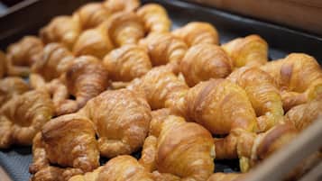 A tray of golden-brown croissants arranged in rows.
