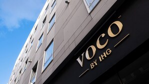 A building with the sign "Voco by IHG" on its facade.