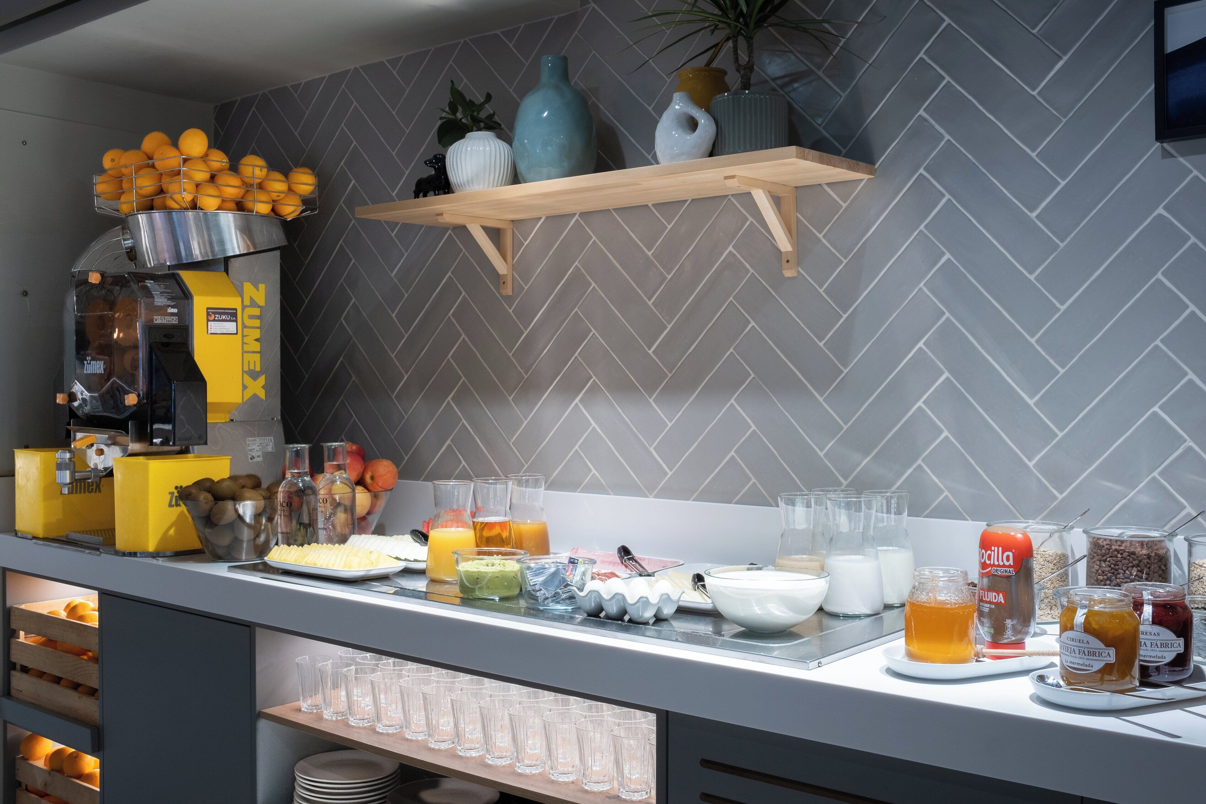 Montaje de bufé con diversos alimentos y bebidas, incluyendo frutas, jugos y salsas.