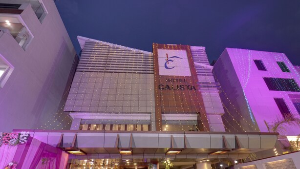Un hôtel doté d’une enseigne bien visible indiquant « HÔTEL CALISTA », d’une architecture moderne et d’une entrée bien éclairée.