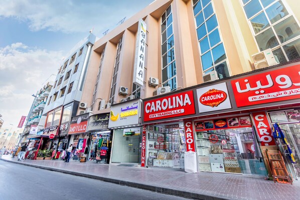 Un immeuble commercial doté de nombreuses vitrines, parmi lesquelles on trouve un hôtel appelé « Banana Hotel » et un magasin appelé « Carolina City Trading LLC ».