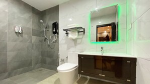 Une salle de bain moderne avec une douche à l’italienne, des toilettes, un lavabo avec un miroir et un porte-serviettes.