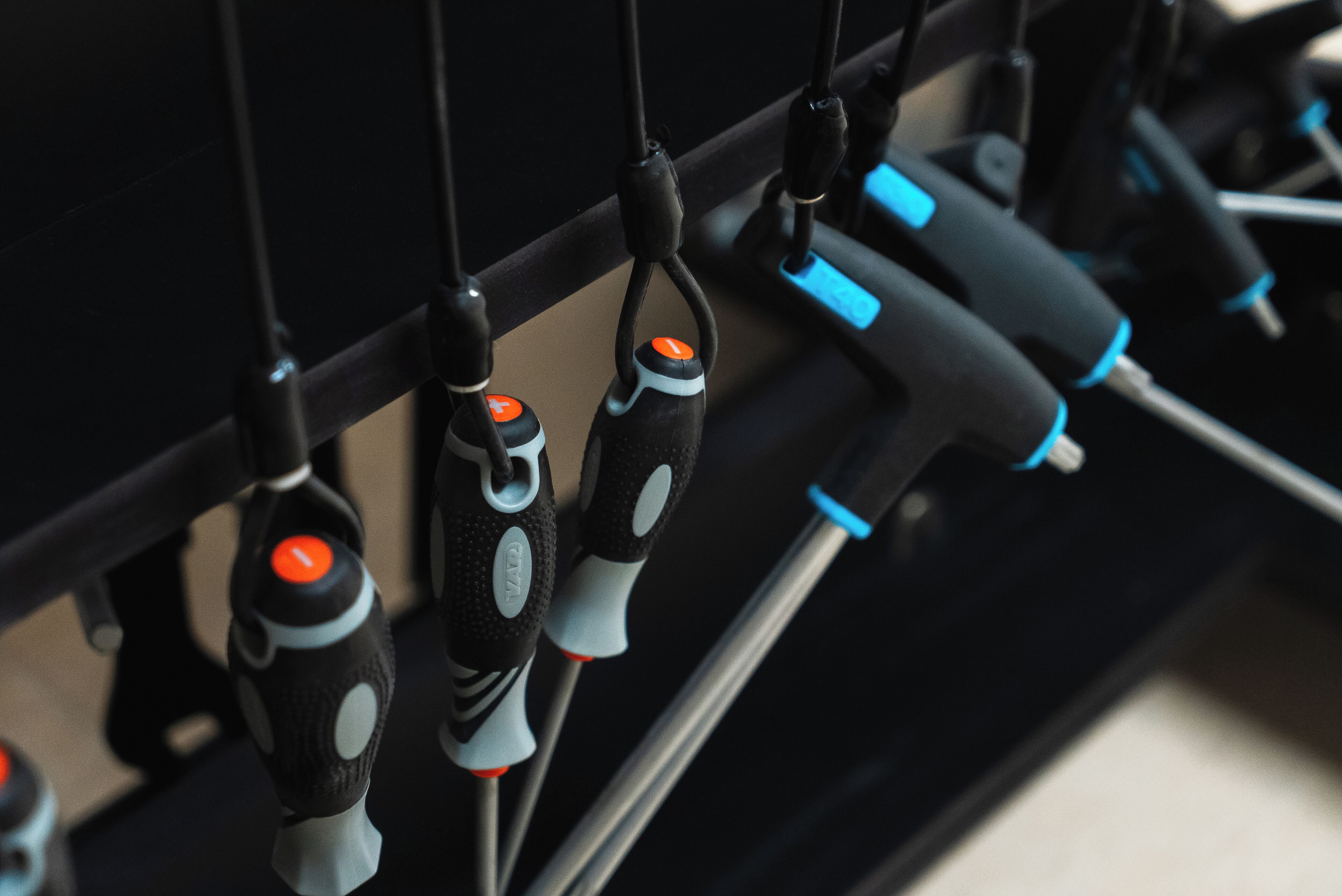 A close-up of a black cable management system with orange and blue connectors.