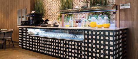 A bar area with a patterned counter, a coffee machine, and a glass display case.