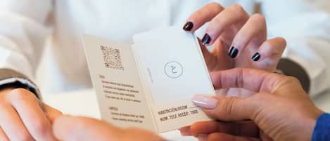 A person holding a hotel card with a QR code and text indicating room number 7000.
