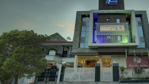 Um edifício moderno com uma placa indicando 'Hotel Prakash Inn'.