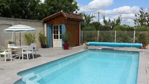 A rectangular swimming pool with a tiled deck, a small wooden shed, and a white fence. - Charming house in Lamonzie-Saint-Martin (Lamonzie-Saint-Martin)