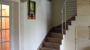 A staircase with wooden steps and metal railings, leading to a landing with a door and a framed picture on the wall. - Charming house in Lamonzie-Saint-Martin (Lamonzie-Saint-Martin)