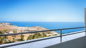 Ein Balkon mit freiem Blick auf das Meer und felsiges Gelände.