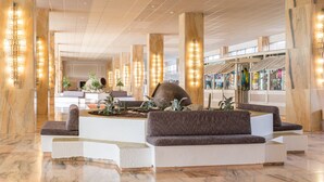 Eine geräumige Lobby mit hohen Decken, Marmorsäulen und modernen Sitzbereichen.