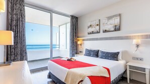 Ein modernes Hotelzimmer mit einem großen Bett, einem Nachttisch und Meerblick.
