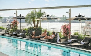 A poolside area with lounge chairs, umbrellas, and a view of a body of water. - Four Seasons Hotel New Orleans (New Orleans)