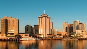 A city skyline with a prominent tower and a river reflecting the buildings.