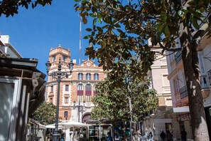 A historic building with a clock tower, surrounded by trees and other buildings. - Apartamento Animalia (Cádiz)