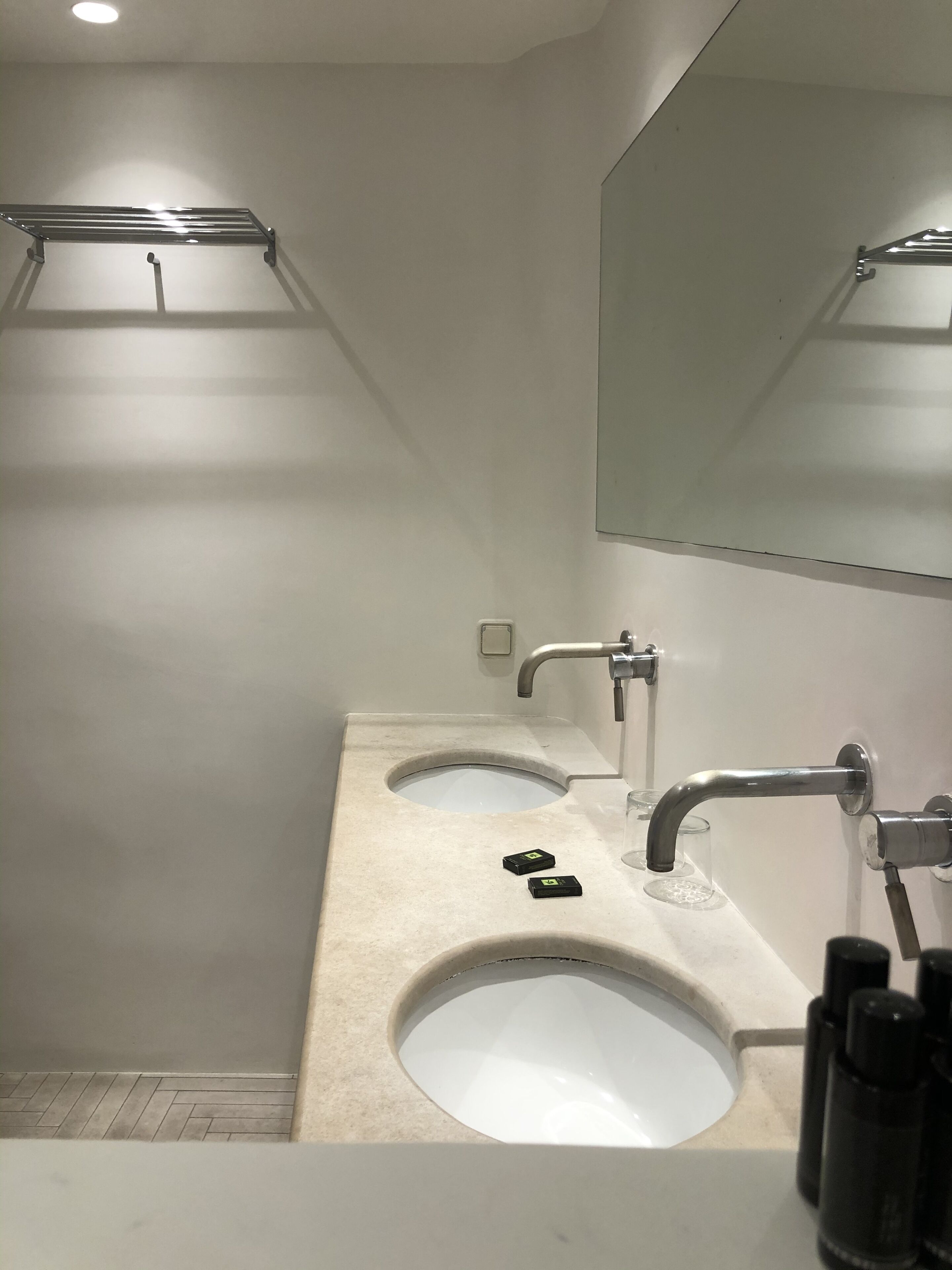 Une salle de bain moderne dotée d’un double lavabo, d’un grand miroir et d’un porte-serviettes.