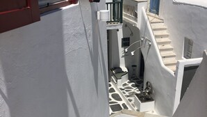 Un edificio de paredes blancas con una escalera que conduce a un balcón.