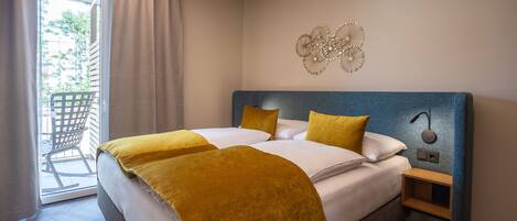 Habitación de hotel con una cama grande, una mesita de noche, un reloj de pared y vistas al exterior a través de una puerta corredera.