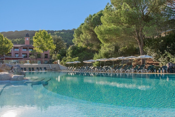 Una piscina al aire libre, sillones reclinables de piscina