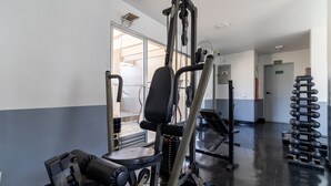 A gym with exercise equipment, a door labeled "SAIDA," and a rack of weights. - BR156166 - Apartamento  Bela Vista 50 meters from Hosp Sírio Libanês with Garage (São Paulo)