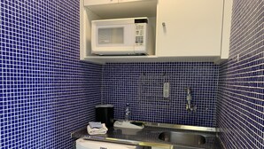 A compact kitchen with a microwave, sink, and small refrigerator. - BR156166 - Apartamento  Bela Vista 50 meters from Hosp Sírio Libanês with Garage (São Paulo)