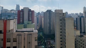A cityscape with high-rise buildings, including a prominent red and beige structure in the foreground. - BR156166 - Apartamento  Bela Vista 50 meters from Hosp Sírio Libanês with Garage (São Paulo)