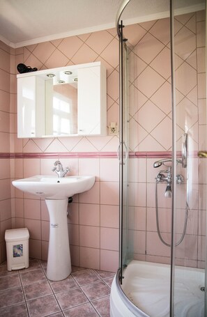 A bathroom with a sink, mirror, and shower. - Villa Thalia Thassos Island Limenaria Greece (Thasos)