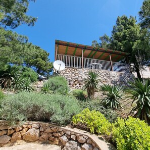 A stone building with a wooden balcony and a satellite dish.