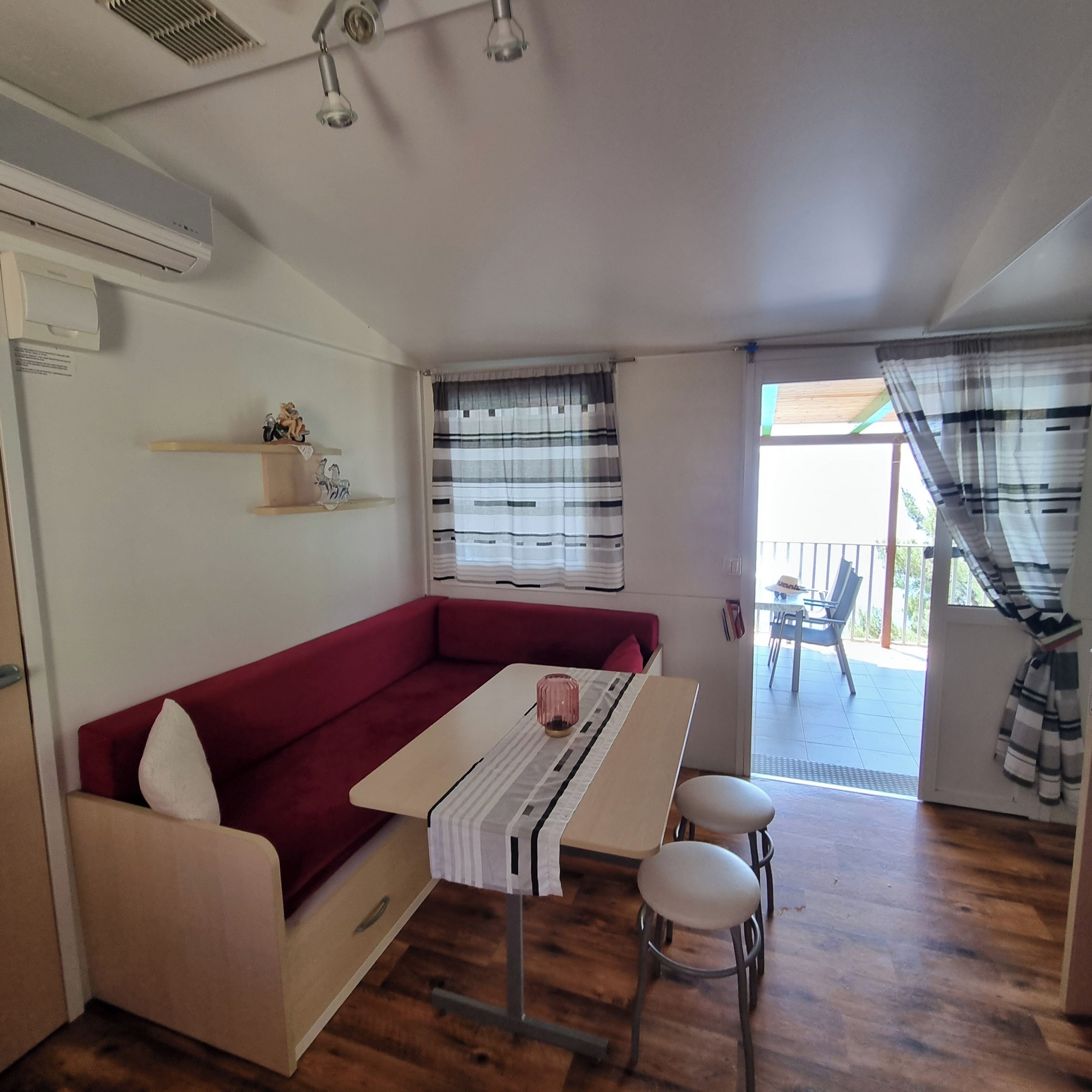 A compact living space with a sofa, a small table, and a dining area.