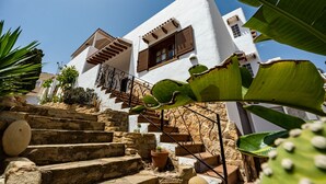 Ein weißes Gebäude mit einer Steintreppe, die zu einer Holztür führt.