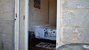 Quarto com cama, mesa de cabeceira e cabeceira fixada na parede.