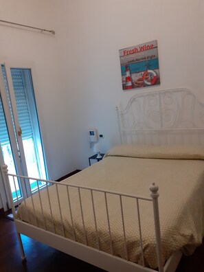 A bedroom with a white bed, a window with blinds, a wall-mounted lamp, and a poster advertising 'Fresh Wine'. - Room in Guest Room - Private Room and Breakfast (Lecce)