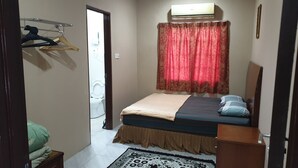 Une petite pièce propre, avec un lit, une table de chevet, une lampe suspendue, une fenêtre avec un rideau et une porte donnant sur une salle de bain.