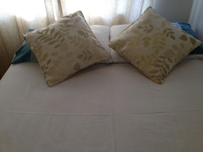 Un letto con due cuscini e una coperta blu.