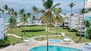 A resort with a pool area, palm trees, and a view of the ocean. - Ocean View, Private Beach, Playa Turquesa (Punta Cana)