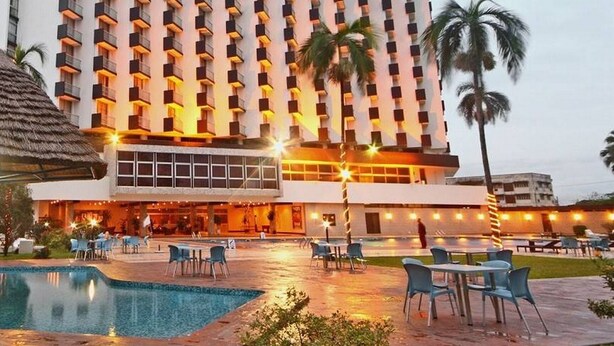 Ein Hotel mit Pool, Außenbereich und einem großen Gebäude mit Balkonen.