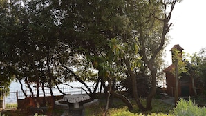 Um parque com uma mesa e cadeiras, uma cerca e um edifício com telhado vermelho.