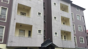 A multi-story building with balconies, large windows, and a central entrance. - Room-christine Apartments-guest Room (Port Harcourt)