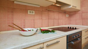 A kitchen with a white countertop, a stove, and a sink. - Apartment Terra (Dubrovnik)