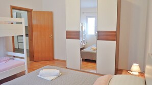 Una camera da letto con letti a castello, un armadio e un comodino con una lampada.