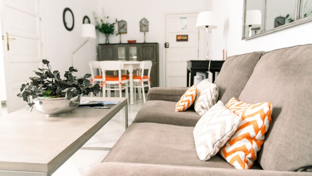 Una sala de estar con sofá, una mesa de centro y una zona de comedor con sillas y mesa.