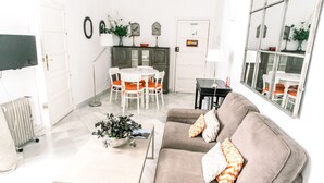 Una sala de estar con sofá, mesa de centro y comedor con sillas y una mesa.