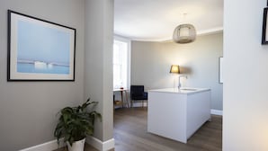 A modern kitchen with a central island, a pendant light, and a framed picture on the wall.