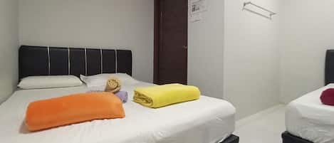 Habitación triple, baño privado | Escritorio y ropa de cama