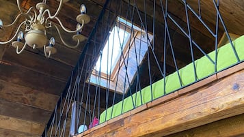 A wooden staircase with a metal railing, a chandelier, and a skylight.