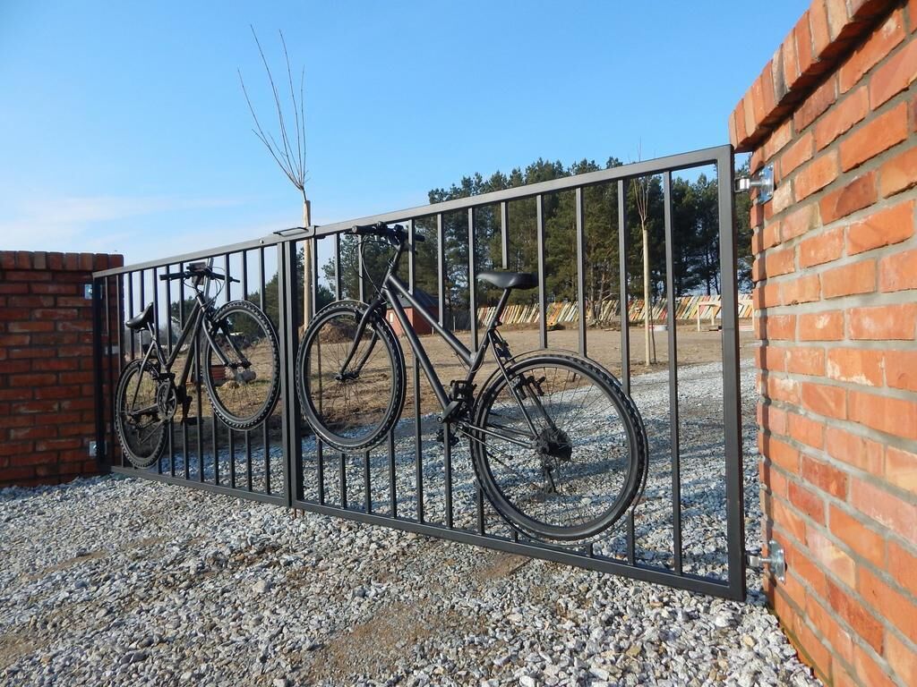 A metal gate with bicycles parked on the other side.