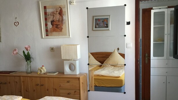 A bedroom with two beds, a wooden dresser, a bedside table with a lamp, and a small cabinet. - Ocean View Apartment Casa Las Playitas – Terrace – 1 Minute to the Beach (Las Playitas)