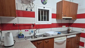 A kitchen with a granite countertop, stainless steel sink, and wooden cabinets. - Ocean View Apartment Casa Las Playitas – Terrace – 1 Minute to the Beach (Las Playitas)