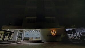 Un edificio moderno con un gran logotipo iluminado en la fachada.