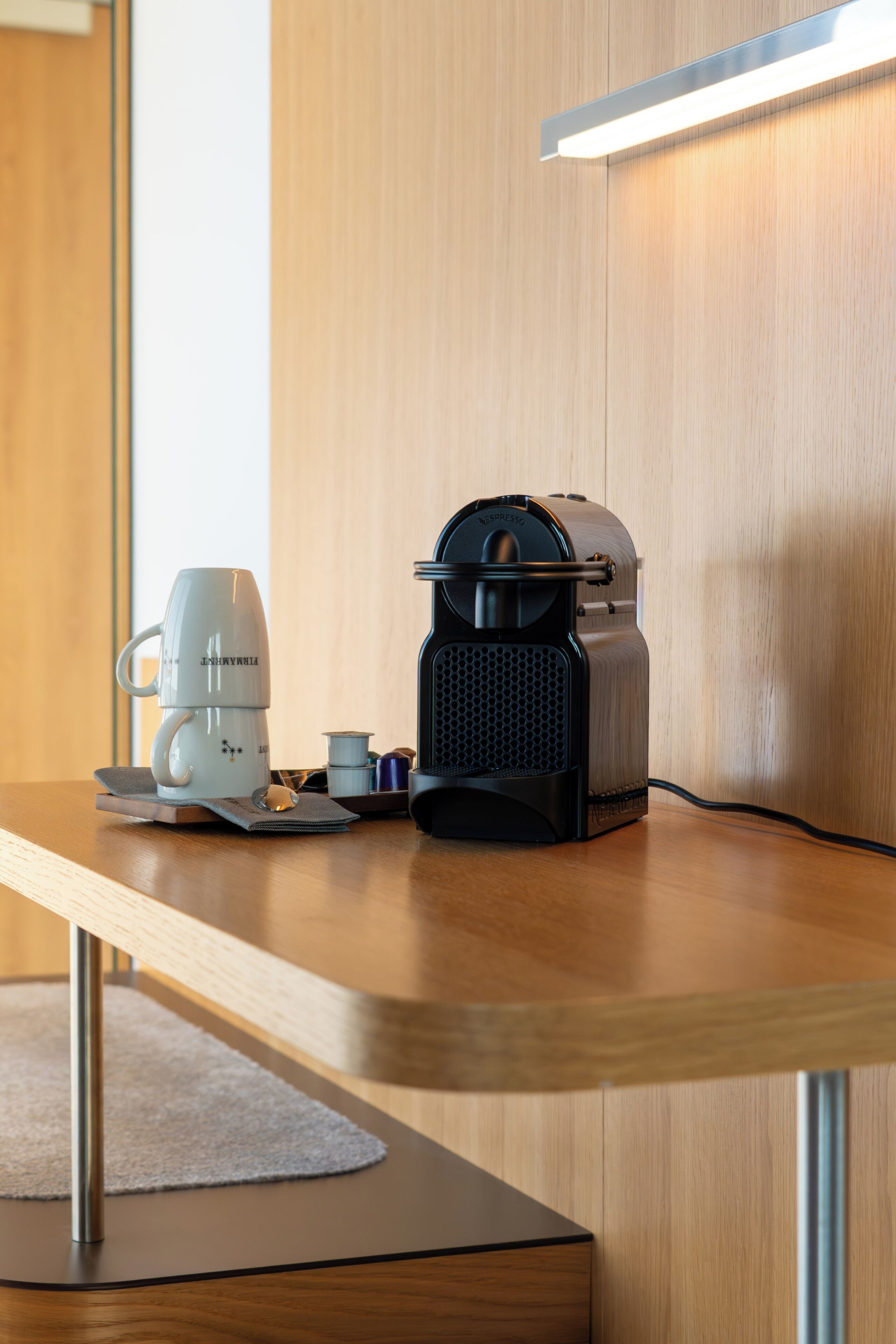 Een houten tafel met een koffiezetapparaat, een draagbare radio en een kop.